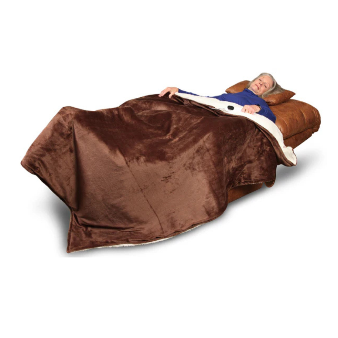 A person rests comfortably on the Journey Perfect Sleep Reclining Lift Chair with Heat, wearing a blue top and covered by a brown blanket. The chair’s therapeutic heat and massage features ensure ultimate relaxation against the plain white backdrop.