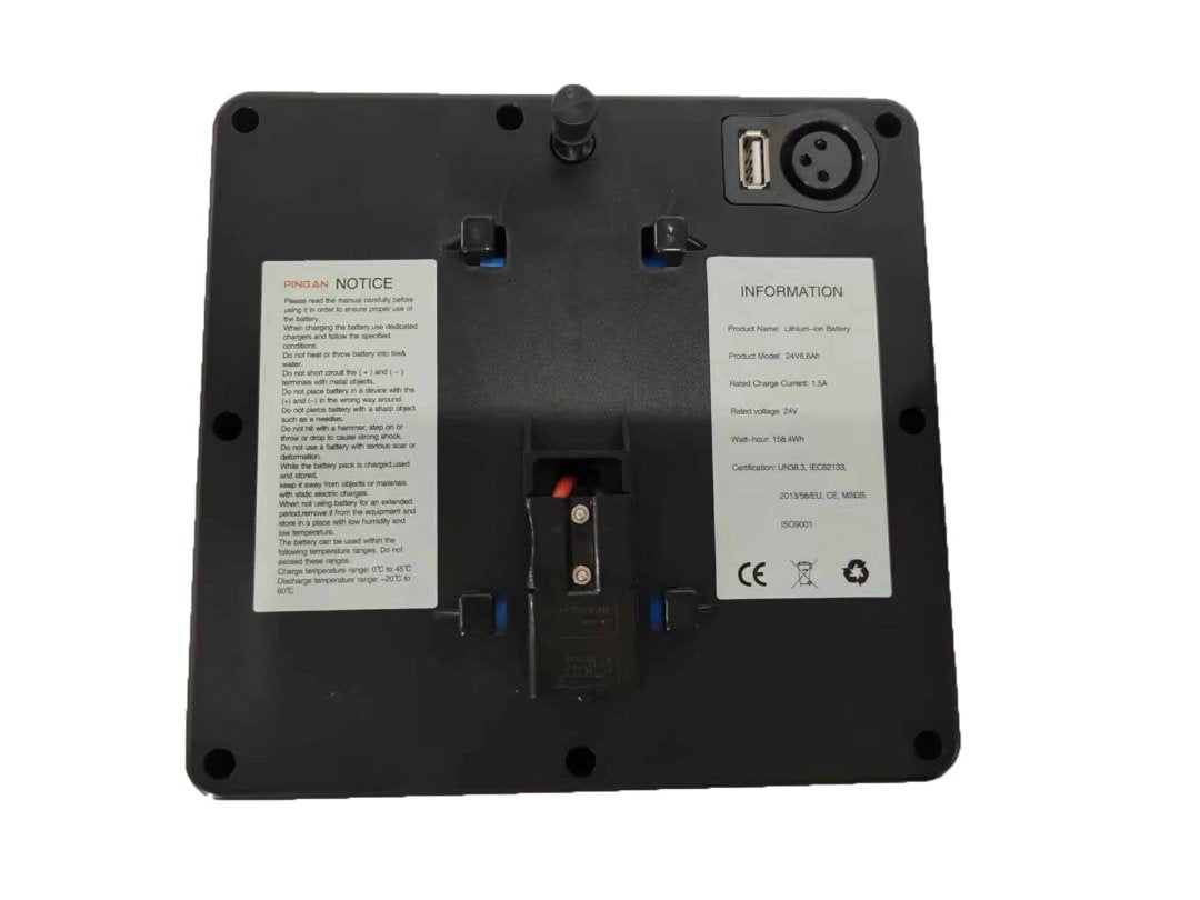 The image shows the back of a ComfyGo Phoenix Carbon Fiber Electric Wheelchair with a sleek finish, featuring informational labels, a small antenna, a USB port, and a connector port. The labels provide product and safety details.
