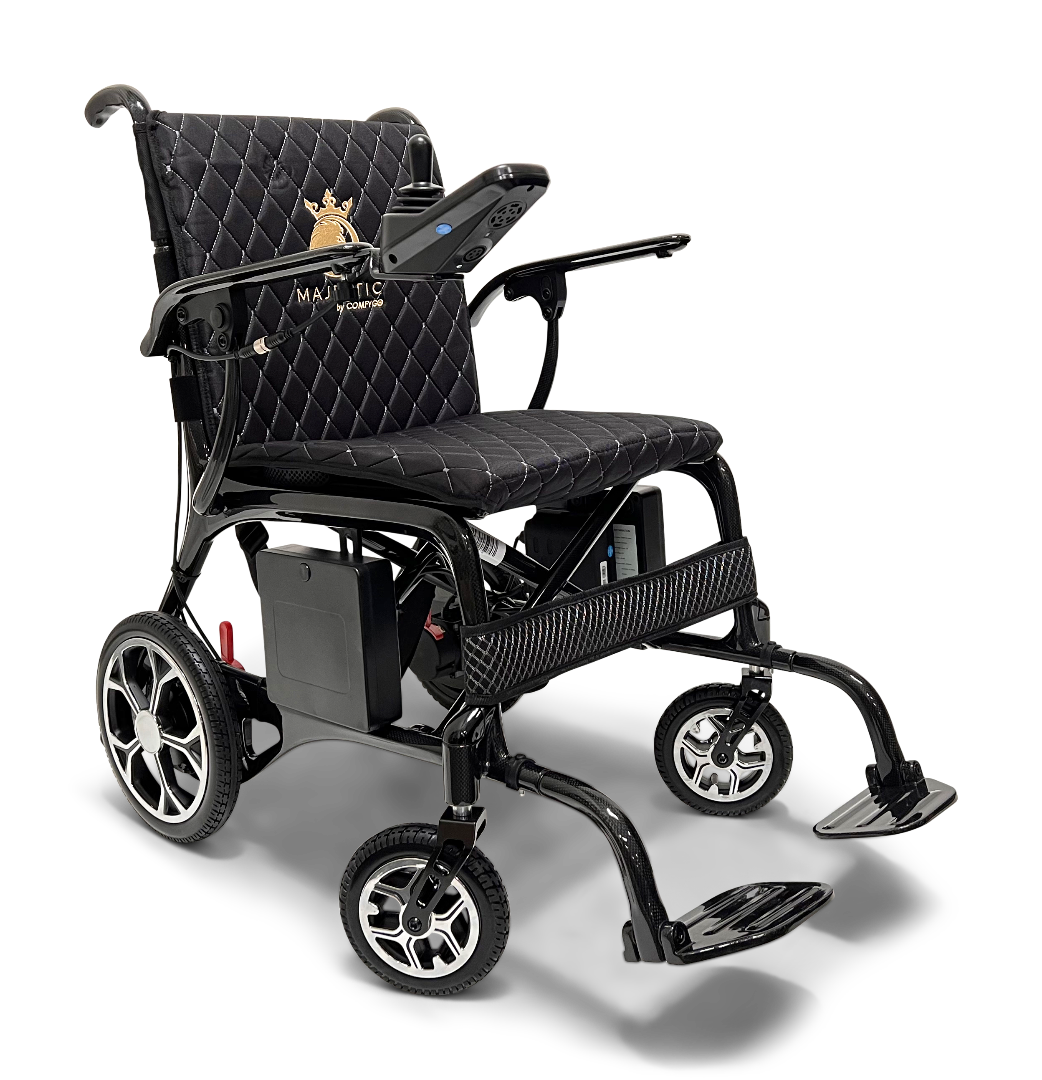 The ComfyGo Phoenix Carbon Fiber Electric Wheelchair features a quilted black seat, armrests, joystick control panel, foldable design with an emblem on the backrest, four wheels, and front-extended carbon fiber footrests.