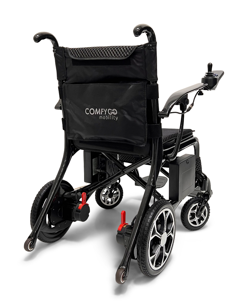 The ComfyGo Phoenix Carbon Fiber Electric Wheelchair, in sleek black with a storage pocket, includes a joystick for control, cushioned seat, and four-wheel build. Its foldable design is highlighted from the back against a white background.