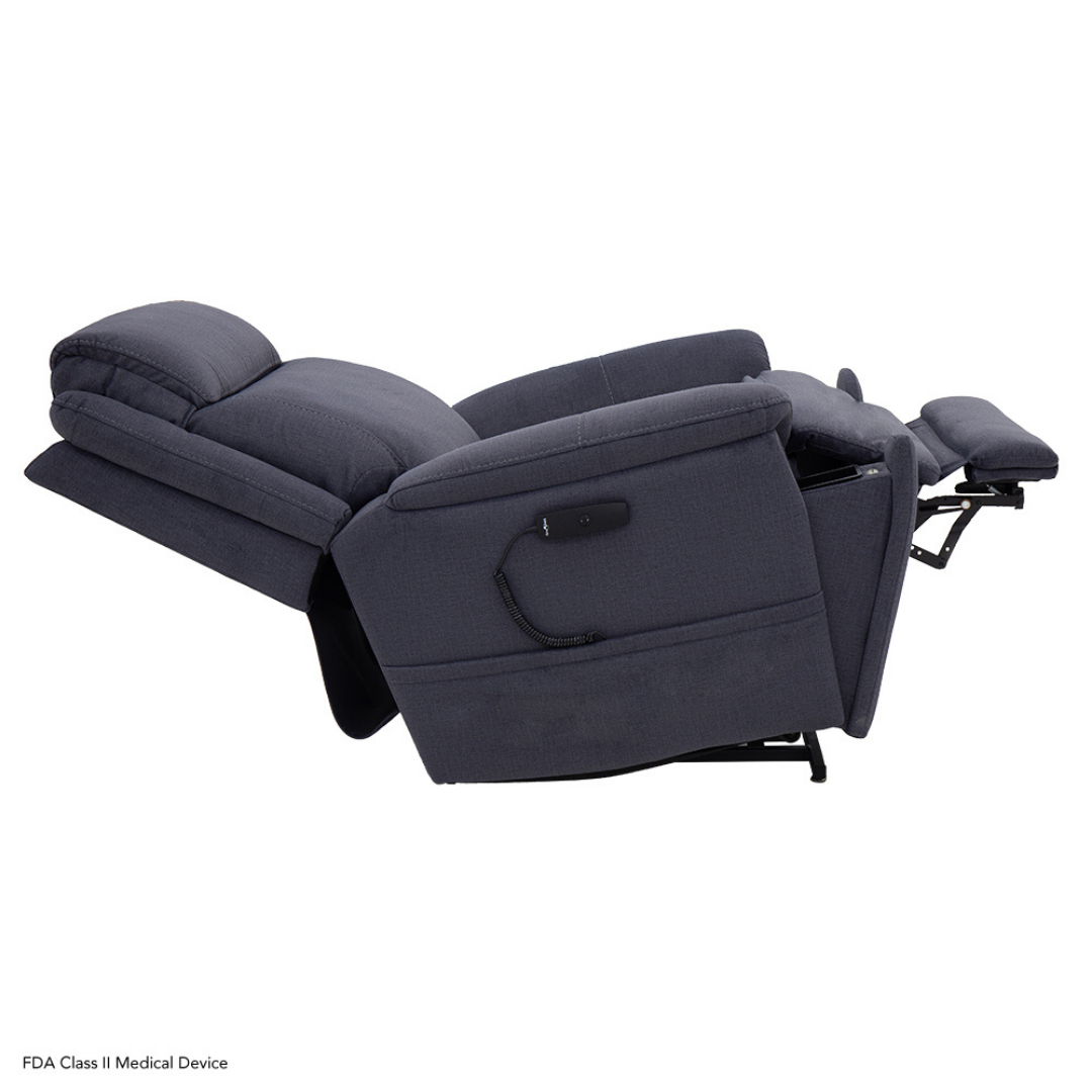 The Pride Mobility Evolution Collection Power Lift Recliner in dark gray is shown fully reclined with the footrest extended and backrest tilted. Premium features include a remote control attached to the chair by a cord.