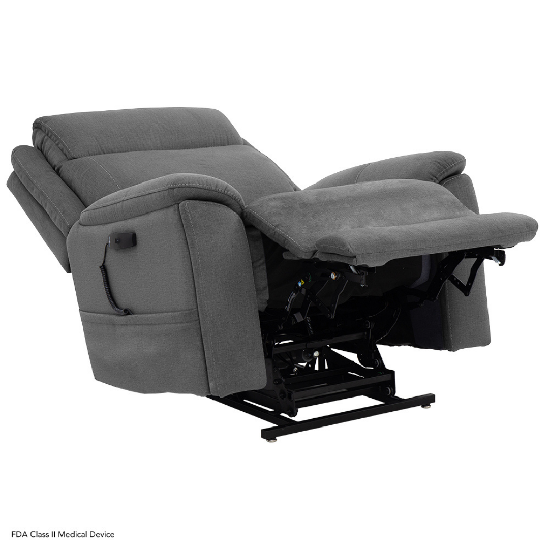 The Pride Mobility Evolution Collection Power Lift Recliner features plush gray fabric, padded armrests and backrest, a side pocket, and a visible black metal frame. Shown partially reclined with an extended footrest.