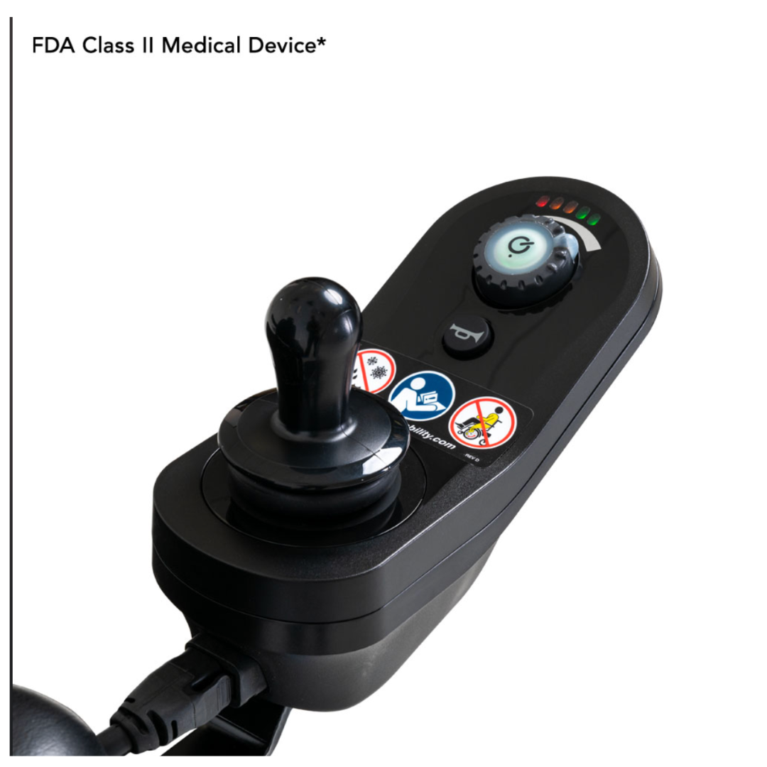 Close-up of a black electronic control panel with a joystick and buttons, labeled FDA Class II Medical Device, featuring visual indicators and icons. It connects to the Pride Jazzy® Elite 14 Powerchair, renowned for its front-wheel drive and robust design.
