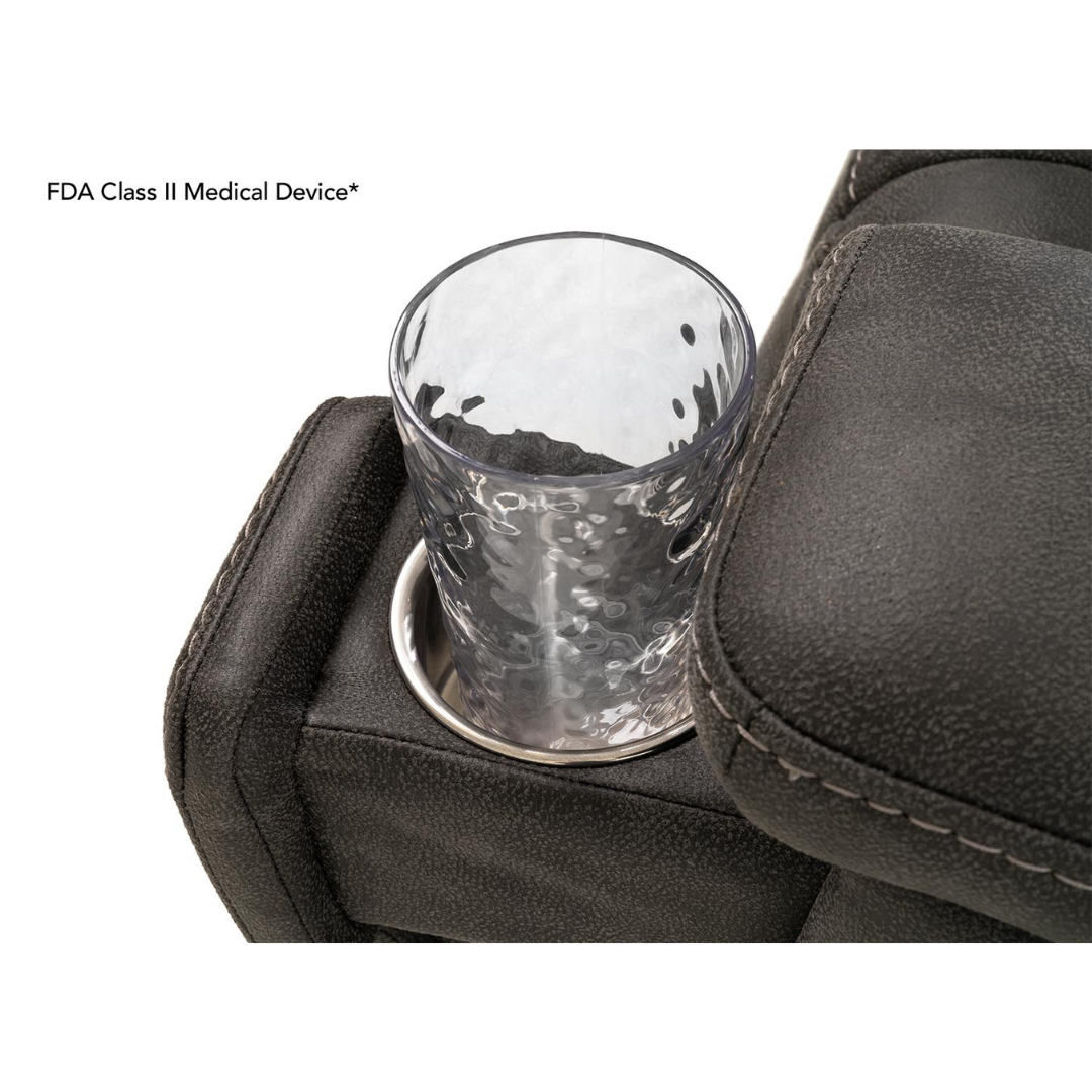 A close-up of a clear, textured glass in a stainless steel cup holder on the dark, padded armrest of the Pride Mobility VivaLift! Radiance Recliner with Lift Assist & Heat. Text on image: FDA Class II Medical Device*.