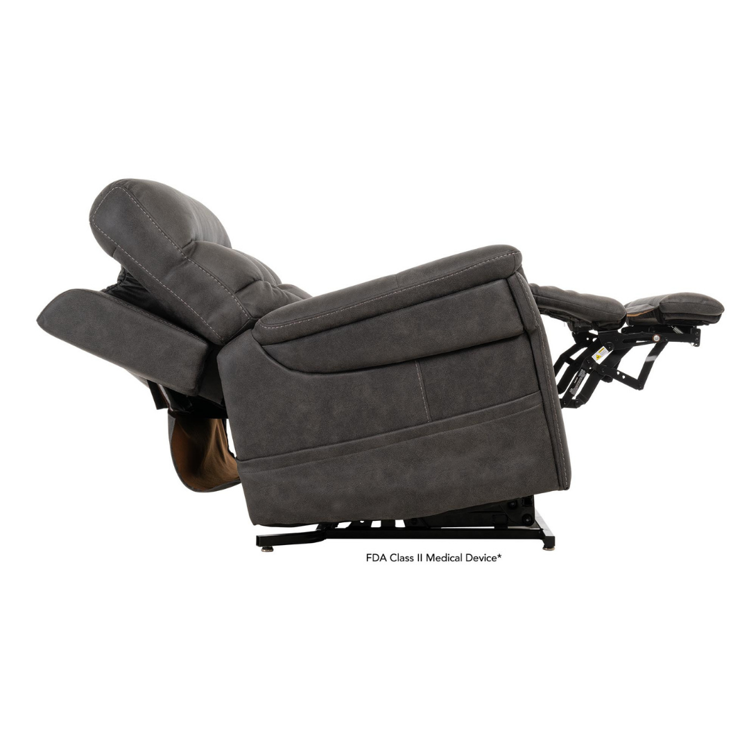 The Pride Mobility VivaLift! Radiance Recliner with Lift Assist & Heat is shown fully reclined in dark gray, with infinite positioning for comfort, a tilted backrest, extended footrest, and soft leather-like upholstery.