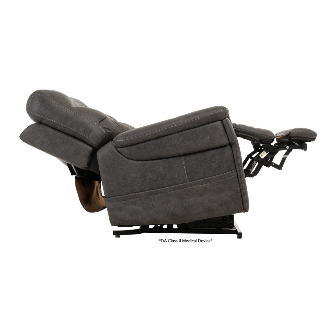 The Pride Mobility VivaLift! Radiance Recliner with Lift Assist & Heat in dark gray is shown from the side, fully reclined with the footrest extended, offering infinite positioning on a white background.