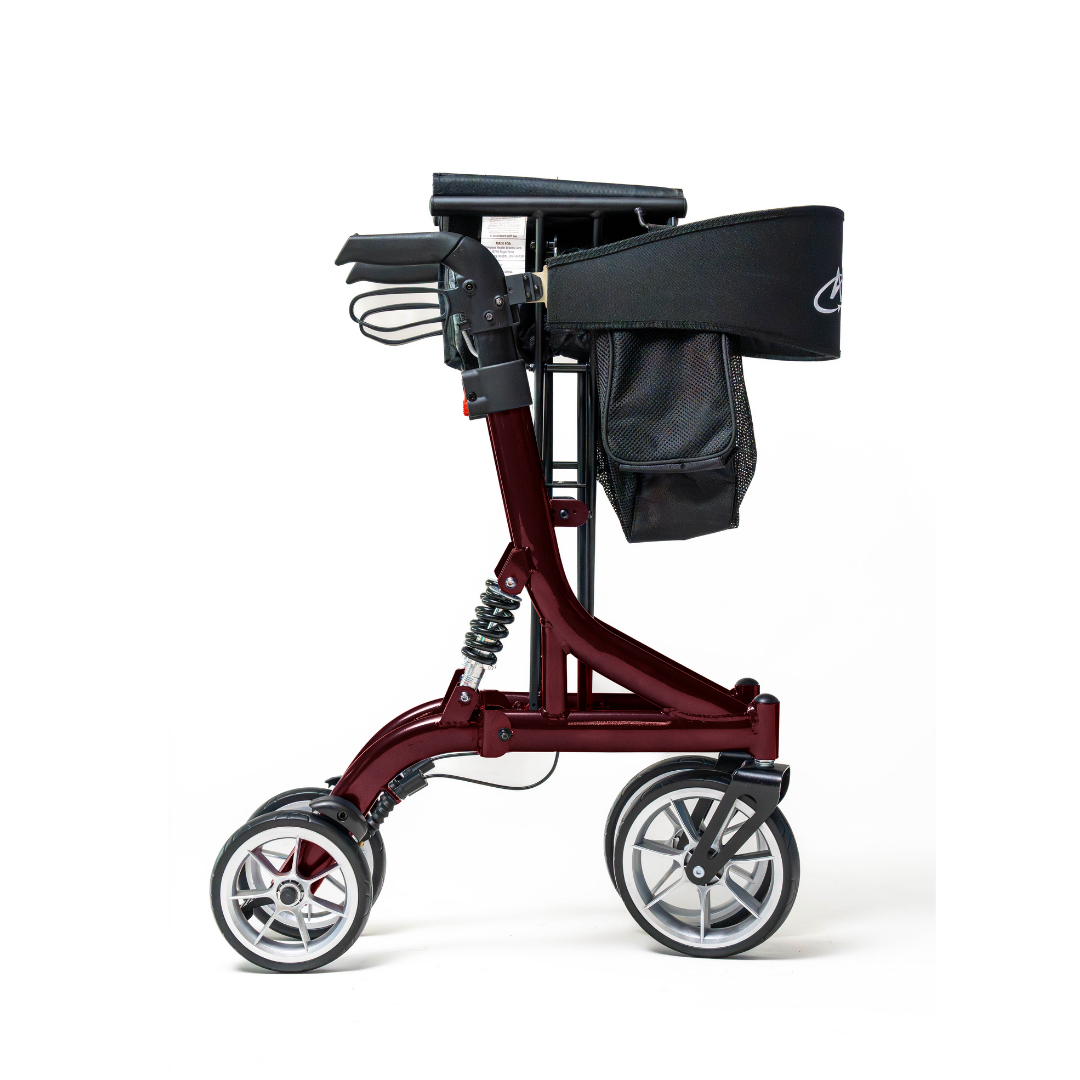 The Probasics Ascent XR™ Euro-Style Bariatric Rollator with Suspension is a modern, maroon heavy-duty walker featuring three large wheels, ergonomic handlebars, black storage bag, cushioned seat, and padded backrest. Shown folded for compact storage.