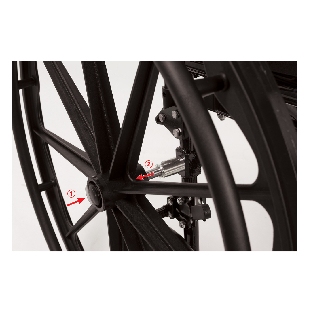 Close-up of a black wheel with metal spokes and axle on the ProBasics K4 Transformer Hybrid Transport Wheelchair, with two red arrows (1 and 2) indicating key components near the wheel hub and axle connection point.