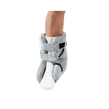 A person’s lower leg and foot in a white sock wear the Proactive Protekt® Heel Gel Elevation Boot with Hot or Cold Gel Pack, a gray padded boot with two Velcro straps for pressure sore prevention, shown against a white background.