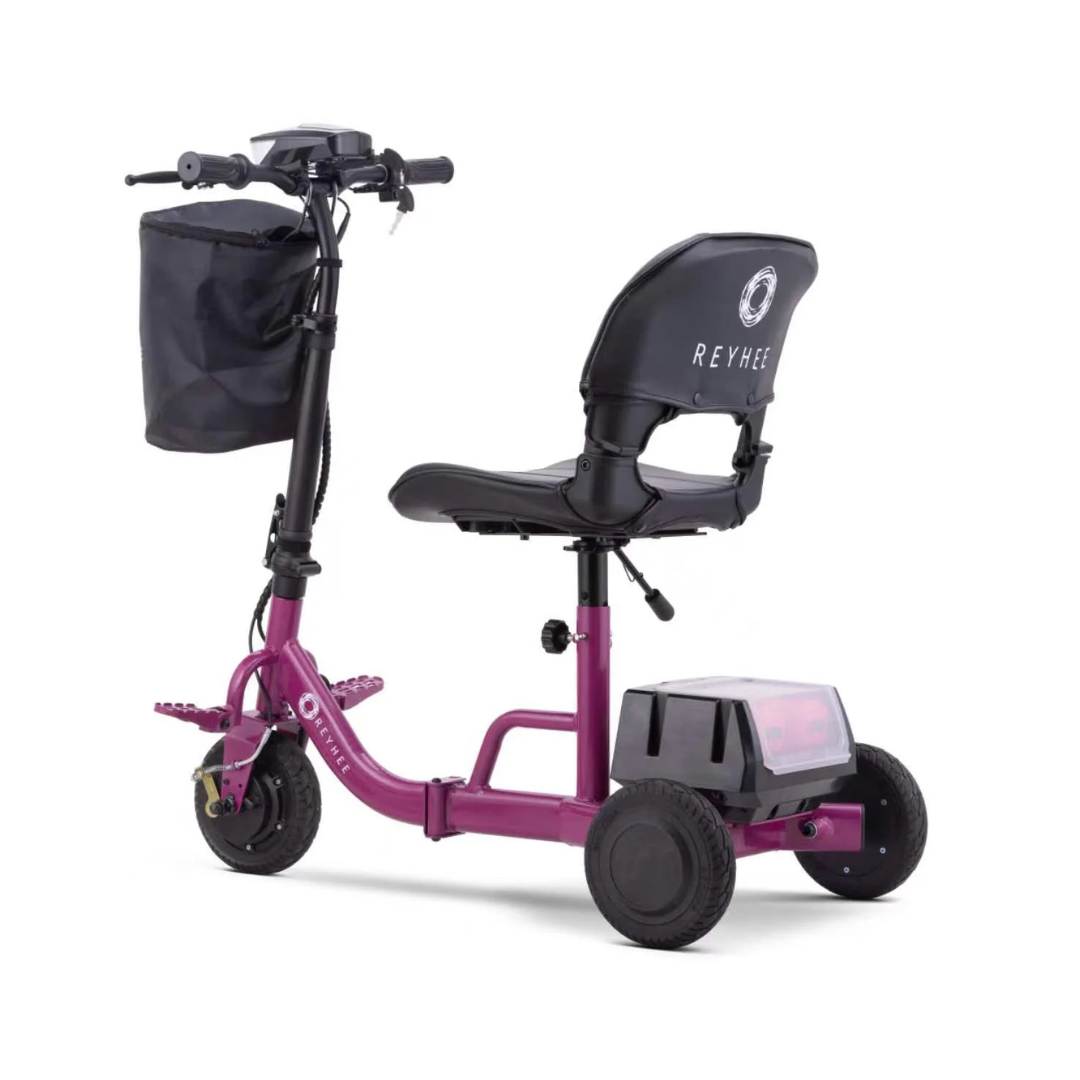 The Reyhee Triad Compact Folding Electric Mobility Scooter is red with three wheels, a black seat and backrest, handlebars with controls, a front black basket, rear storage, and features a portable Swap & Go Battery System for ultimate convenience.