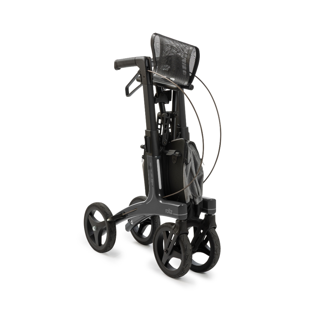 The Rollz Air Lightweight Folding Carbon Rollator, weighing just 10.4 lbs, is shown in black and gray with a mesh seat and storage pouch, folded for easy transport or storage against a plain white background.