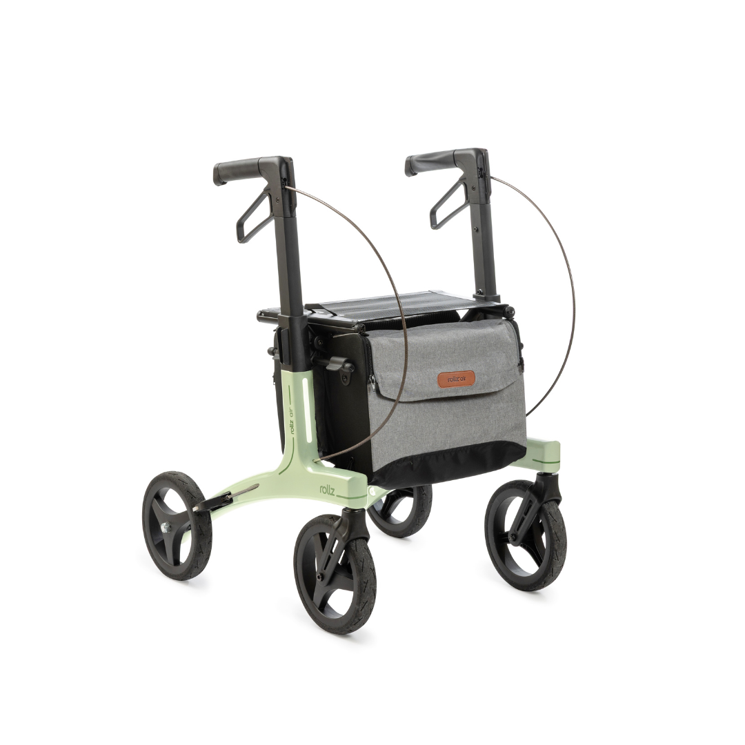 The Rollz Air Lightweight Folding Carbon Rollator (10.4 lbs) features a light green frame, large black wheels, ergonomic handles, and a gray fabric front storage bag.