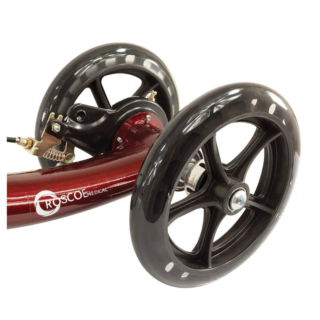 Close-up of two large black wheels on the Roscoe Portable Lightweight Rolling Knee Walker’s red frame, showing sturdy construction with visible bolts and metal parts for dependable mobility support.