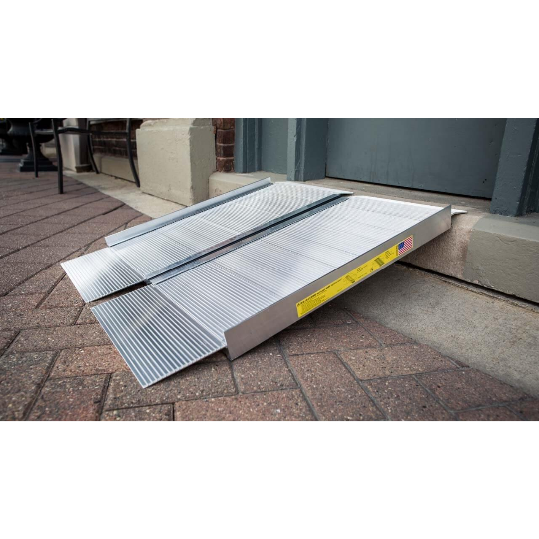 The EZ-Access SUITCASE® Singlefold Mobility Ramp - Portable creates accessible entry from the brick sidewalk to a building entrance over a curb; see specifications and warranty details for more information.