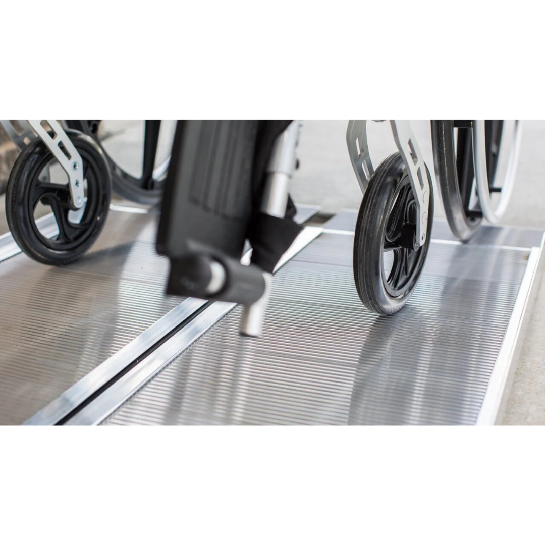 Close-up of the EZ-Access SUITCASE® Singlefold Mobility Ramp’s grooved surface as wheelchair wheels ascend, ensuring secure and easy mobility. For specifications and warranty details, watch our videos.