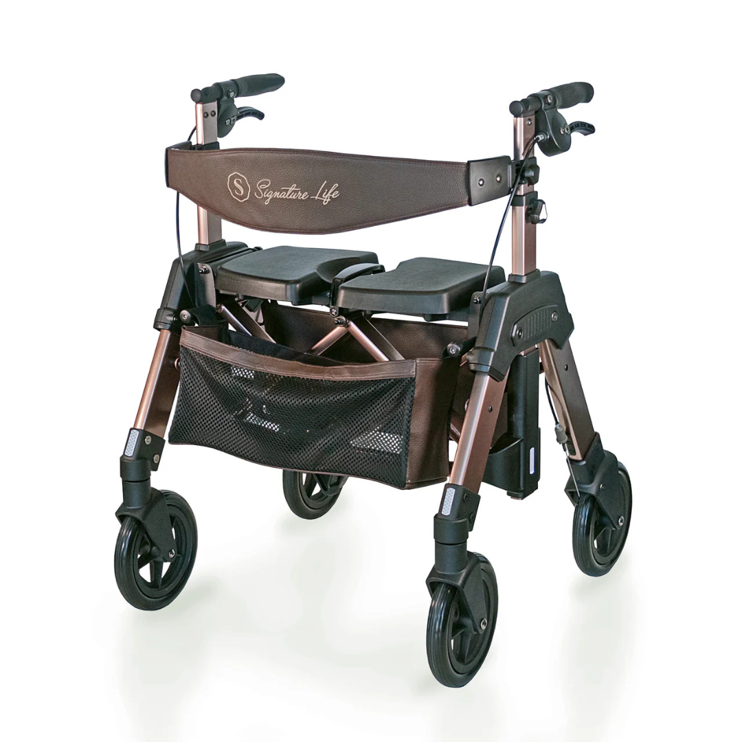 The Signature Life Elite Travel Rollator HD is a foldable brown and black four-wheel rollator with curved handles, a padded extra-wide seat, front mesh storage pouch, and visible Signature Life branding on the backrest.