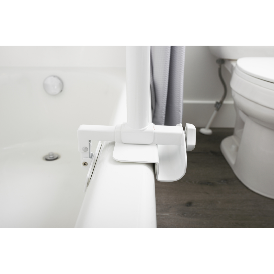 The Stander Wonder Bathtub Pole is securely clamped to the side of a tub near a toilet and shower curtain, providing sturdy fall prevention support for safe entry or exit.