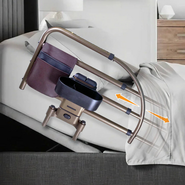 The Signature Life Freedom Click Extendable Bed Rail attaches to your bed for fall protection and features a storage pouch. Orange arrows show its adjustable height next to white bedding and a modern nightstand.