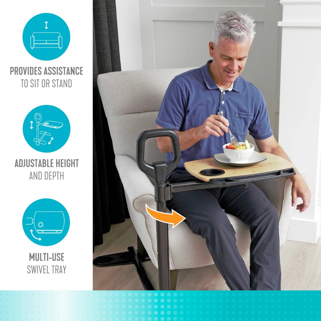A smiling older man eats from a bowl on the Stander Assist-A-Tray—an adjustable, multi-use swivel tray table with a black stand and standing handle, providing assistance to sit or stand. Icons show its height-adjustable and versatile features.
