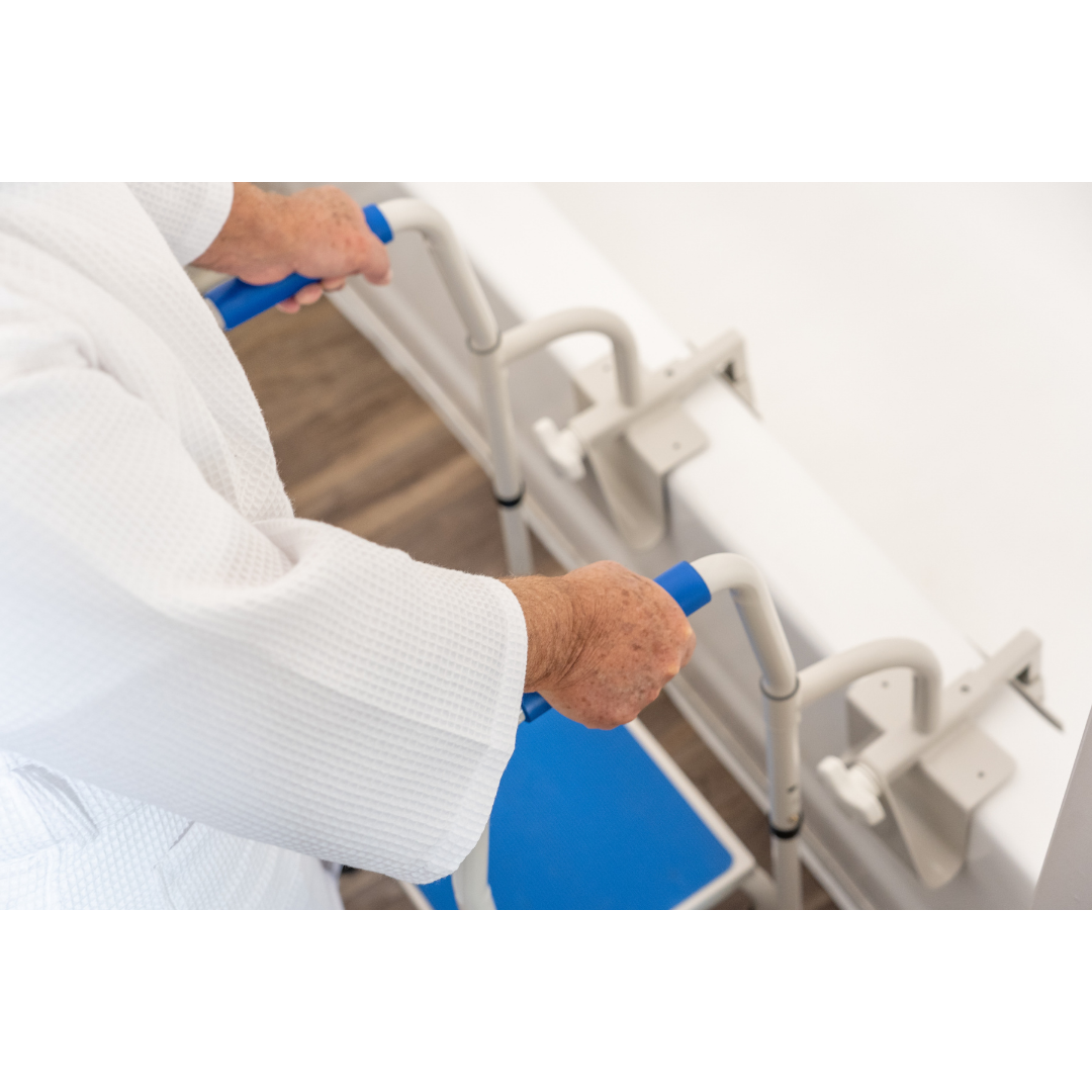 An elderly person uses the Step2Tub Bathtub Step Stool, holding its blue and white grab bars beside a tub, highlighting the importance of fall prevention and secure mobility support during bathing.