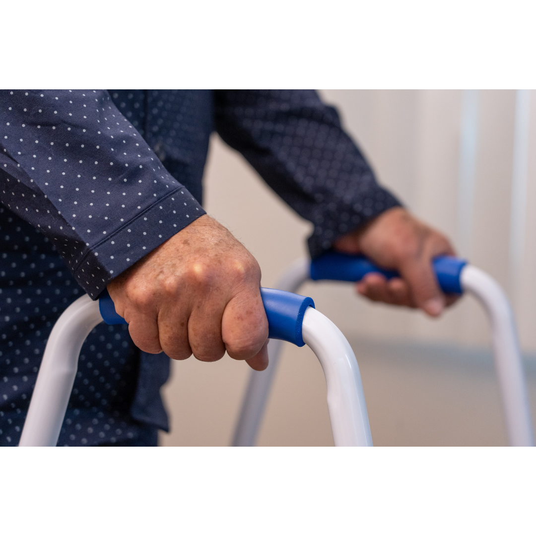 Close-up of a person gripping the handles of the Step2Bed Mini Bedside Stepper, highlighting its support and fall prevention features for safer bedside mobility.