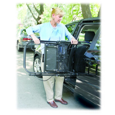 A woman stands by an open car door, holding the U-Step Neuro Walking Stabilizer— a rolling walker with reverse braking, designed for those with neurological conditions— with greenery in the background.