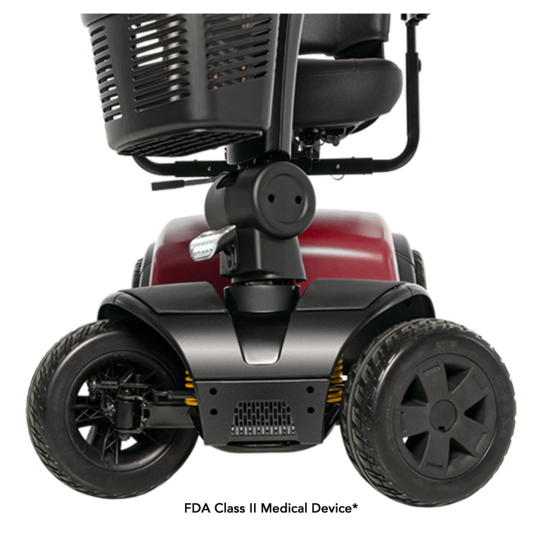 Close-up of the front wheels and base of the Pride Mobility Victory® Platinum Bariatric 4-Wheel Scooter, showcasing EZ Turn technology, a red frame, black tires, a footrest, and partial views of the seat and basket above.