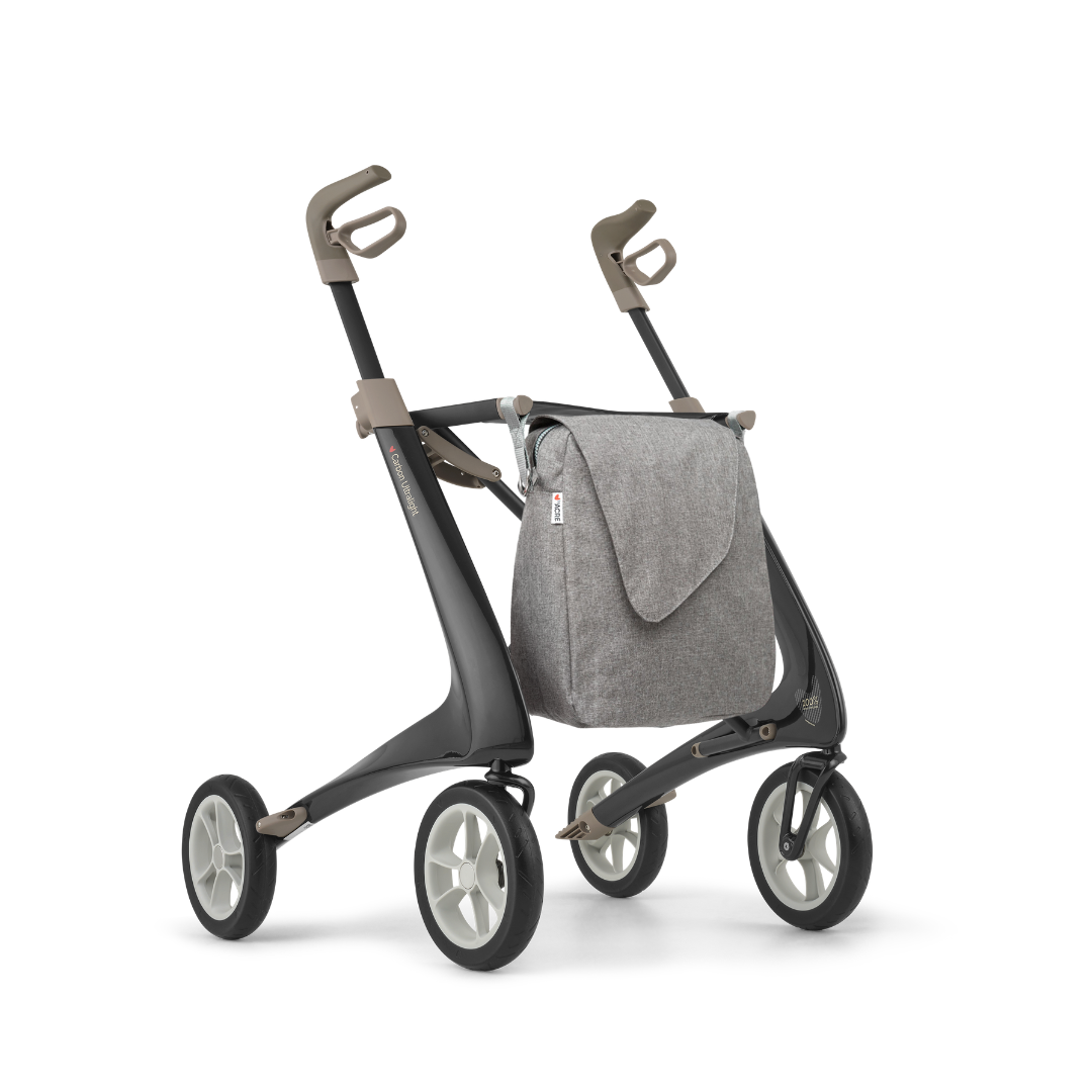 The Weekend Bag for ByAcre Carbon Fiber Rollators features a large gray fabric design that attaches to the front, complementing your modern four-wheeled walker. See product specifications for details.