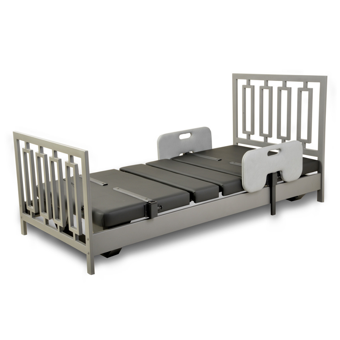 The Assured Comfort® Signature Series Hi-Low Adjustable Bed features a silver frame, black cushions, raised head and footboards, and two vertical mid-bed side rails for patient support.
