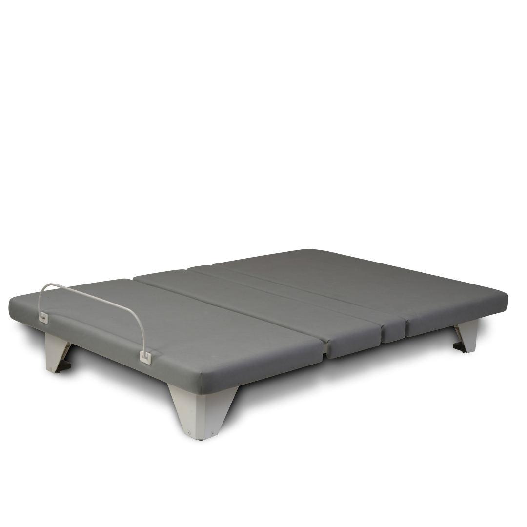 The Assured Comfort® Signature Series Hi-Low Adjustable Beds is a modern, low-profile gray split-king bed with segmented mattresses, white angled legs, and a metal safety rail on one side, shown against a plain white background.