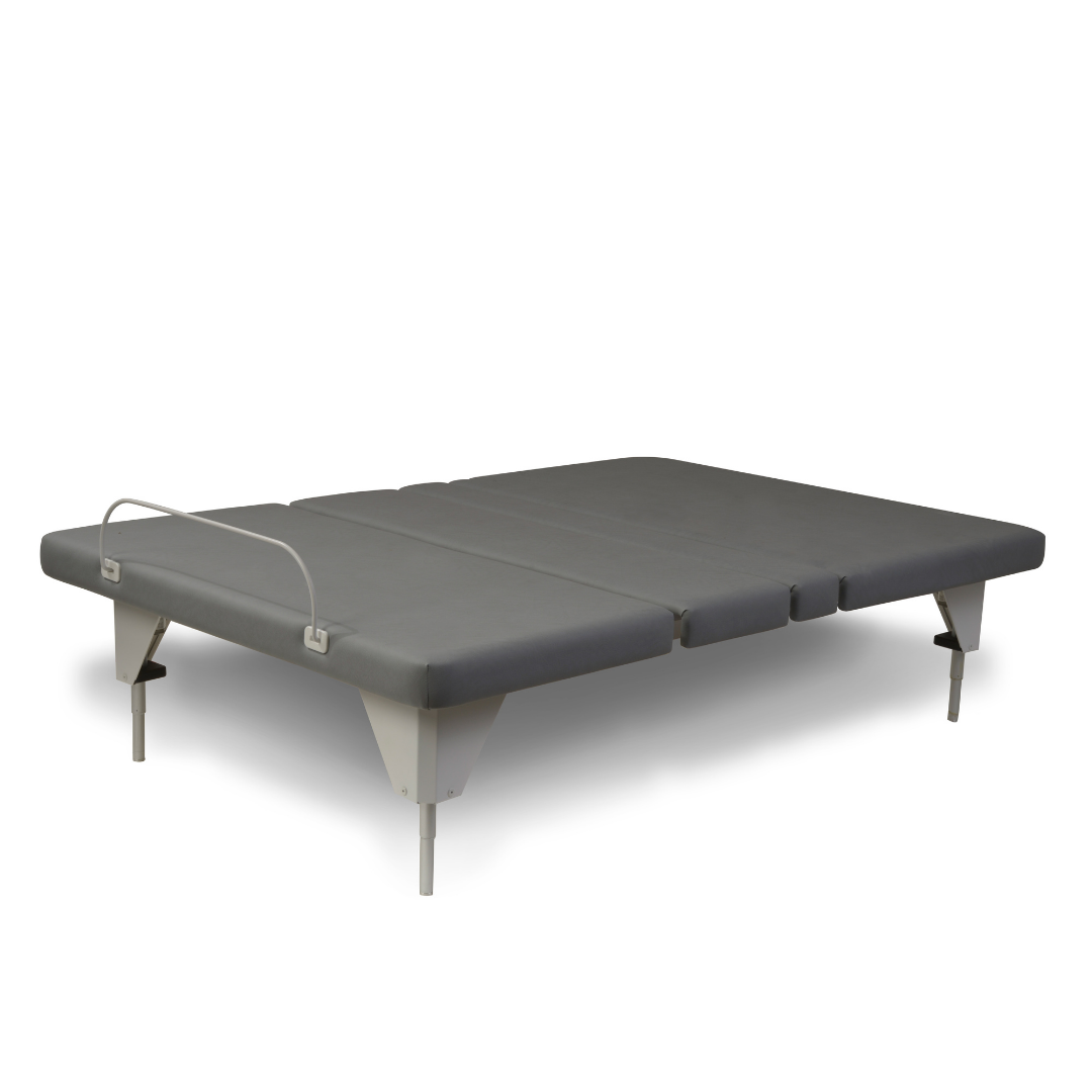 The Assured Comfort® Signature Series Hi-Low Adjustable Bed features a gray padded surface, sturdy metal legs, and a metal retaining bar at the foot to prevent mattress sliding—perfect for split-king setups.