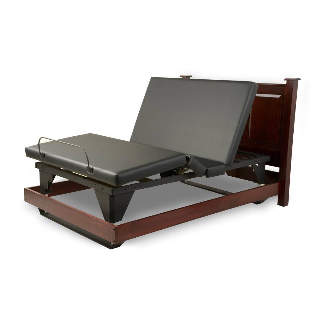 The Assured Comfort® Signature Series Hi-Low Adjustable Bed features a dark wood frame and black mattress, displayed as a split-king with head and leg sections elevated at different angles.