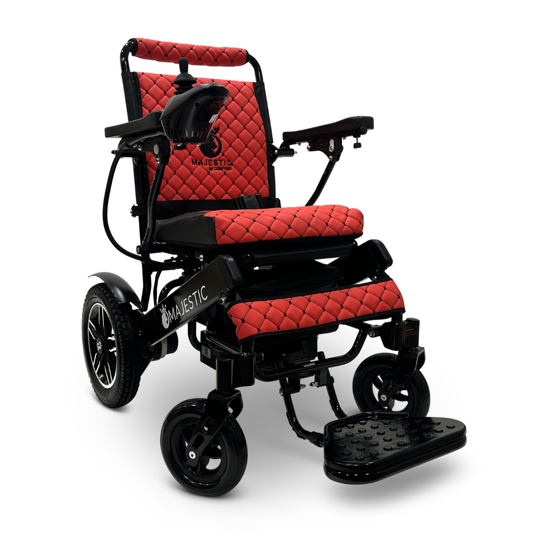 Introducing the ComfyGo MAJESTIC IQ-8000, a portable electric wheelchair in red and black with quilted upholstery. It features a joystick for control on the left armrest and is equipped with durable rubber tires for smooth travel.