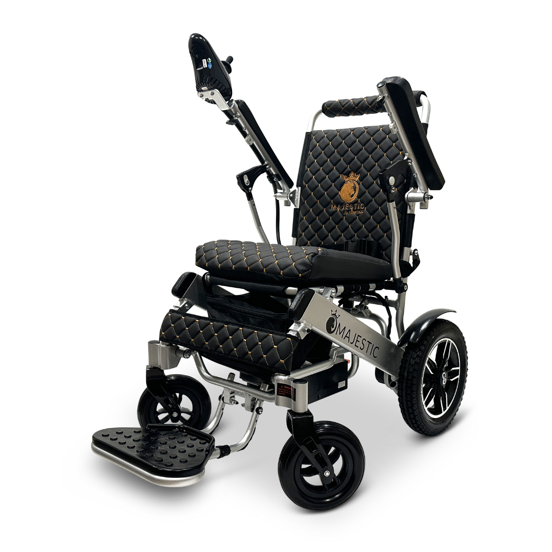 Introducing the ComfyGo MAJESTIC IQ-8000, a luxurious and travel-friendly black electric wheelchair. It features quilted cushions, adjustable armrests, and a footrest for maximum comfort. The lightweight design is adorned with silver metal accents and showcases the logo on the backrest, offering an elegant appearance.