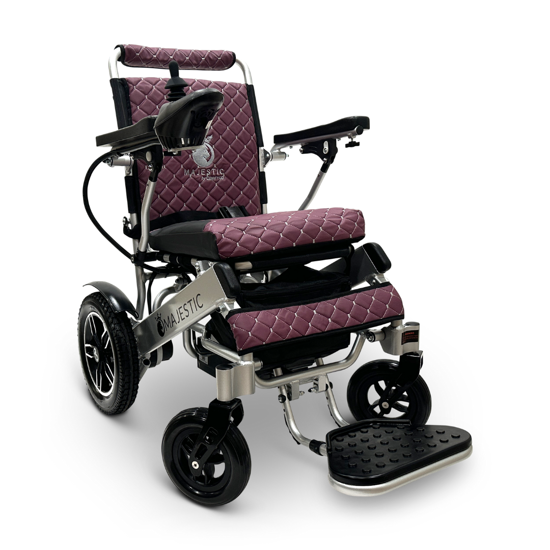The ComfyGo MAJESTIC IQ-8000 Remote Controlled Lightweight Electric Wheelchair is designed for travel, featuring a foldable design with a quilted dark red seat and backrest. It includes four sturdy wheels and a black footrest, providing ease of use and portability for any journey.
