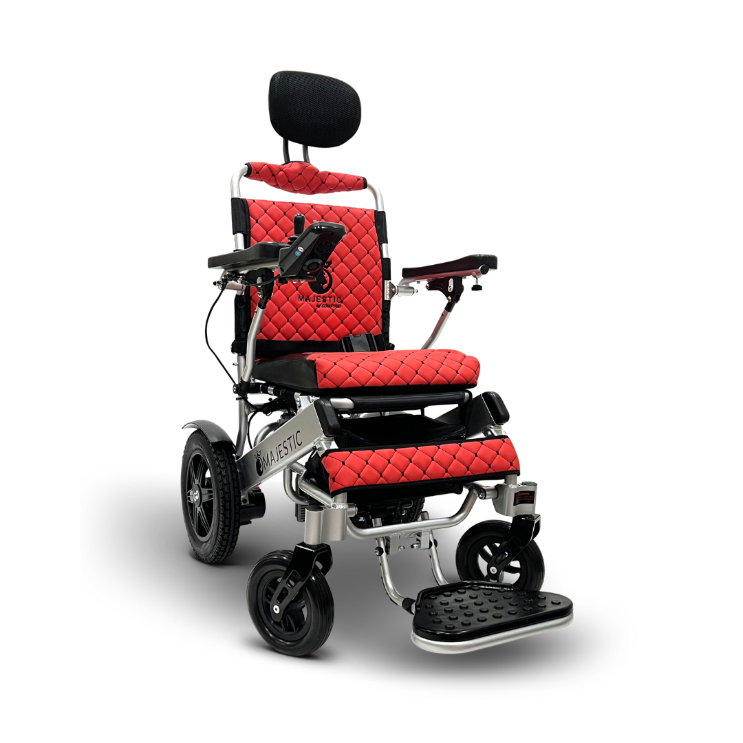 The red ComfyGo MAJESTIC IQ-9000 electric wheelchair features a quilted pattern, black headrest, and armrests. It has medium back wheels, smaller front ones, a footplate, Majestic branding, and an advanced digital joystick controller against a plain white background.