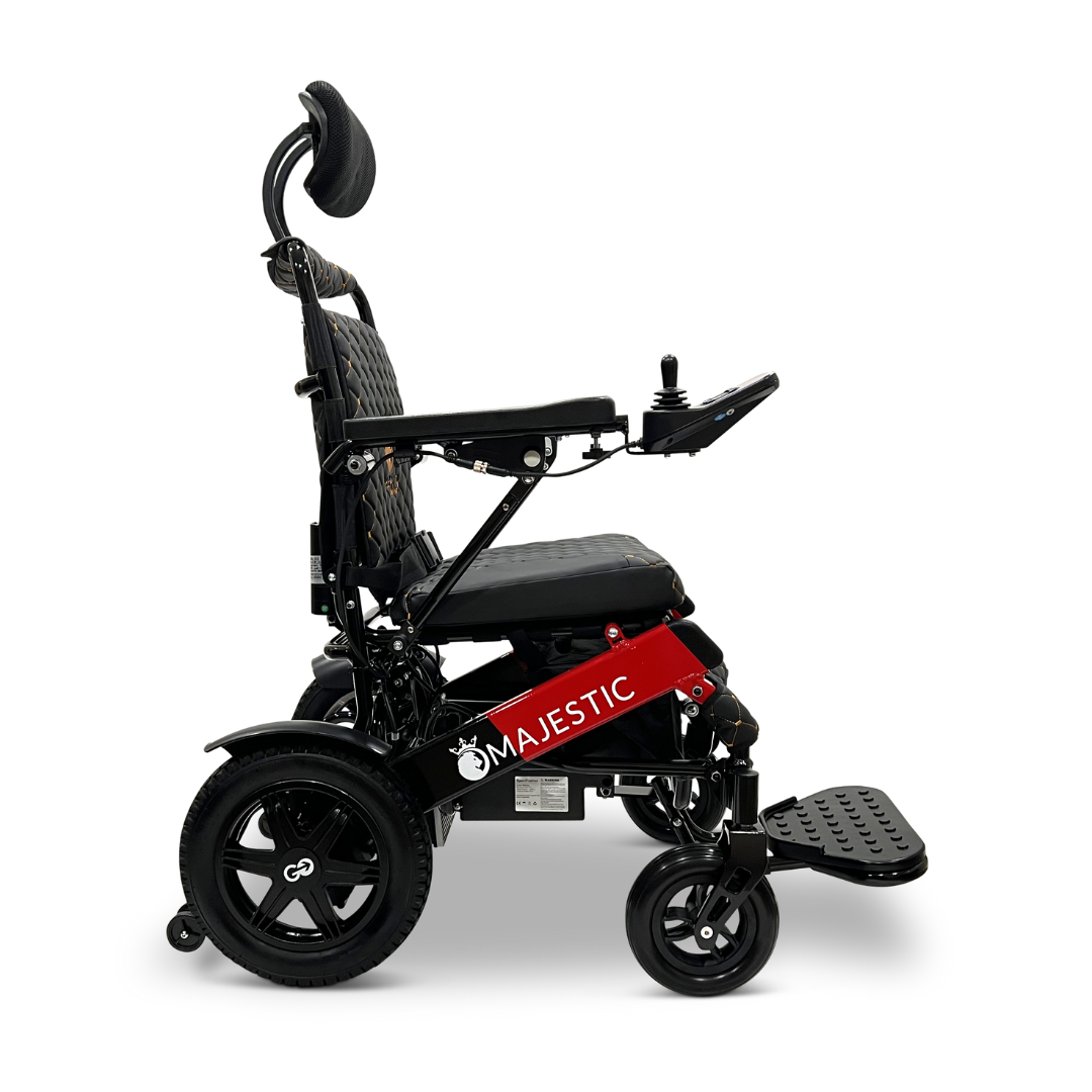 Seen from the side, the ComfyGo MAJESTIC IQ-9000 Auto Recline Remote Controlled Electric Wheelchair showcases its sleek black and red design. This model is equipped with brushless silent motors, ensuring a smooth ride. It offers a comfortable seat complete with headrest and footrest, while the word "Majestic" is elegantly inscribed on its side panel alongside a digital joystick controller for easy navigation.