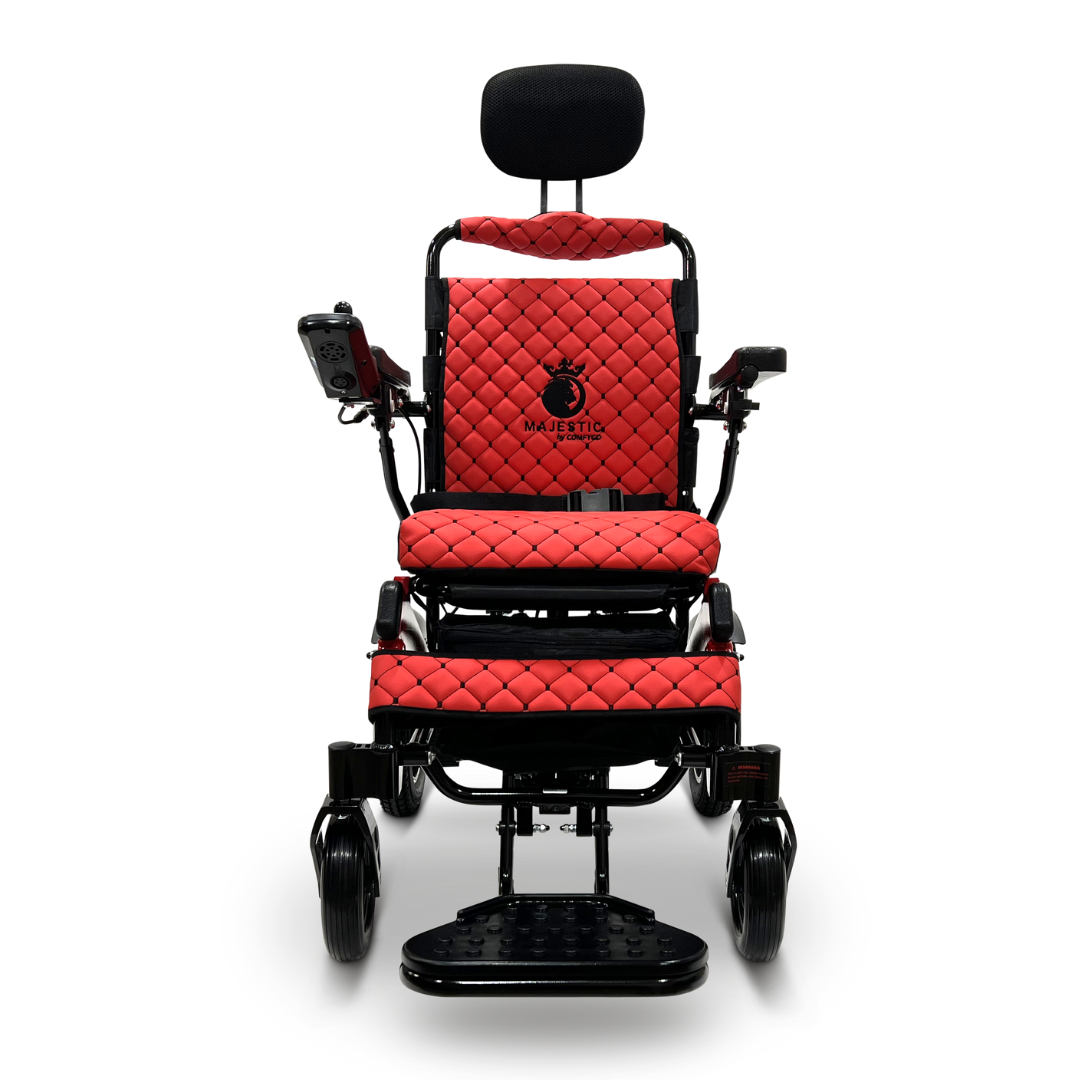 The ComfyGo MAJESTIC IQ-9000 Auto Recline Remote Controlled Electric Wheelchair showcases a red and black design, complete with a quilted seat, headrest, and the Majestic logo. Equipped with brushless silent motors and a digital joystick controller on the armrest, it offers both comfort and state-of-the-art technology for seamless mobility.