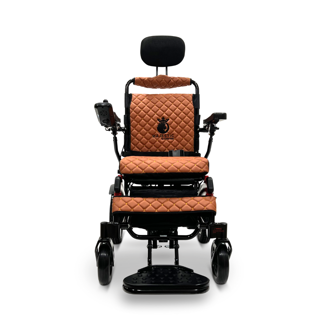The ComfyGo MAJESTIC IQ-9000 Auto Recline Remote Controlled Electric Wheelchair in brown features a quilted leather design with a cushioned seat and backrest. It includes armrests equipped with a digital joystick controller on the right, footrests, and a headrest. Brushless silent motors ensure smooth and noiseless forward movement.