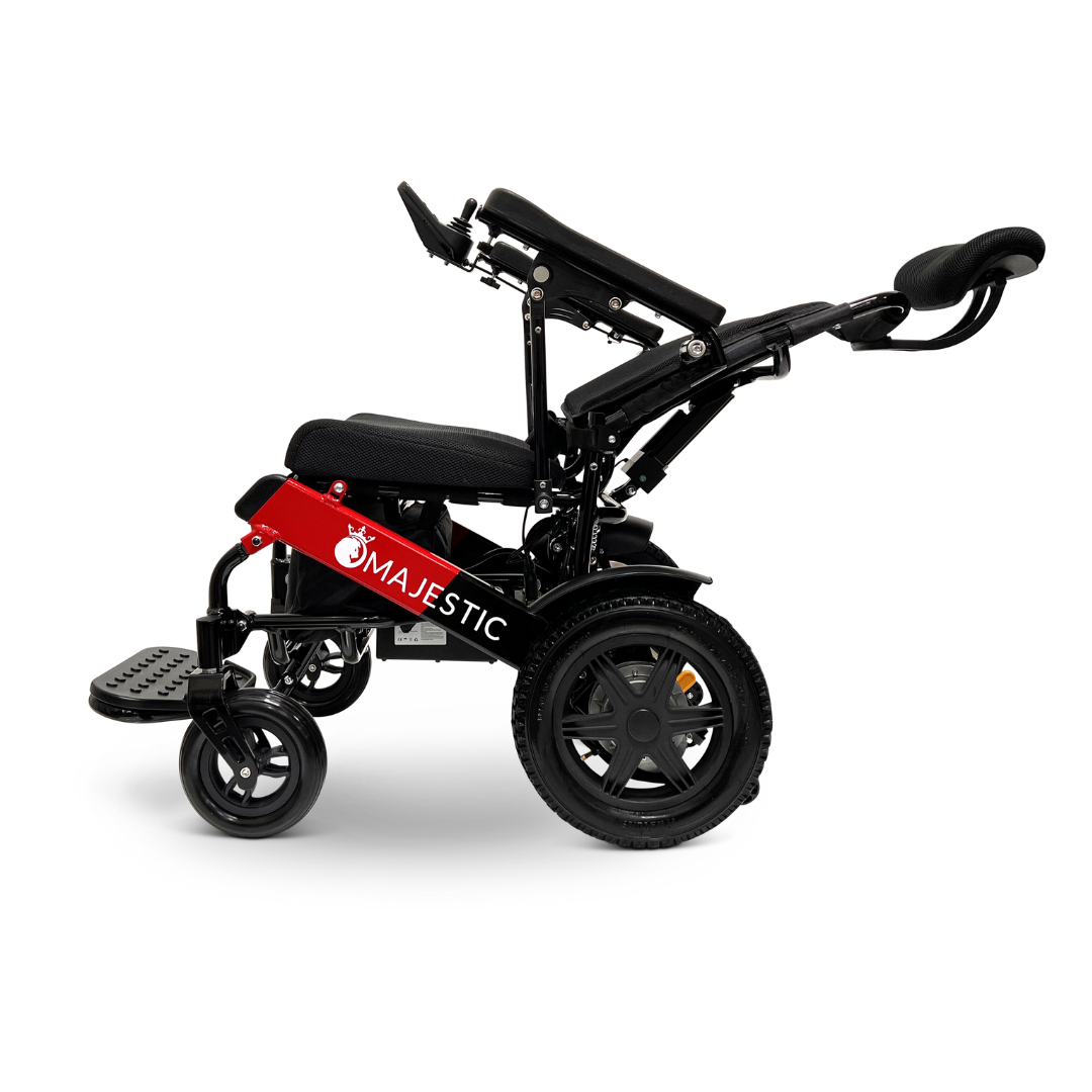 A ComfyGo MAJESTIC IQ-9000 wheelchair with large rear wheels and small front wheels is depicted. It features brushless silent motors, adjustable seat and backrest, armrests, a footrest, and the brand name Majestic displayed on the side. The wheelchair comes in a red and black color scheme.