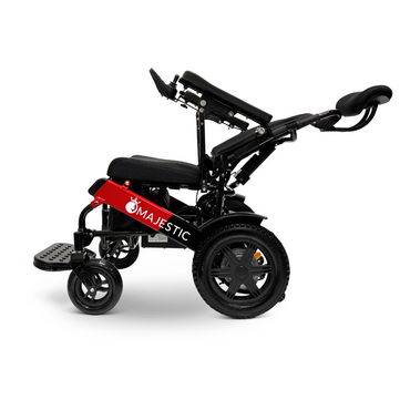 A ComfyGo MAJESTIC IQ-9000 wheelchair with large rear wheels and small front wheels is depicted. It features brushless silent motors, adjustable seat and backrest, armrests, a footrest, and the brand name Majestic displayed on the side. The wheelchair comes in a red and black color scheme.