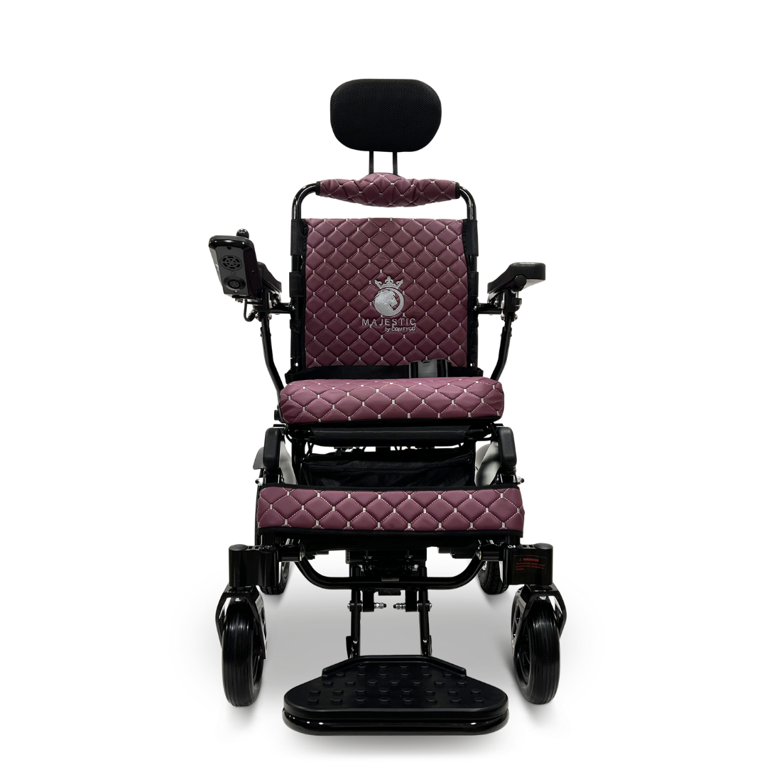 The ComfyGo MAJESTIC IQ-9000 Auto Recline Remote Controlled Electric Wheelchair showcases a stylish front view with a diamond-patterned burgundy seat and backrest. It is equipped with black armrests, a headrest, and a digital joystick controller on the right armrest. The adjustable footrest enhances the smooth ride provided by its brushless silent motors.