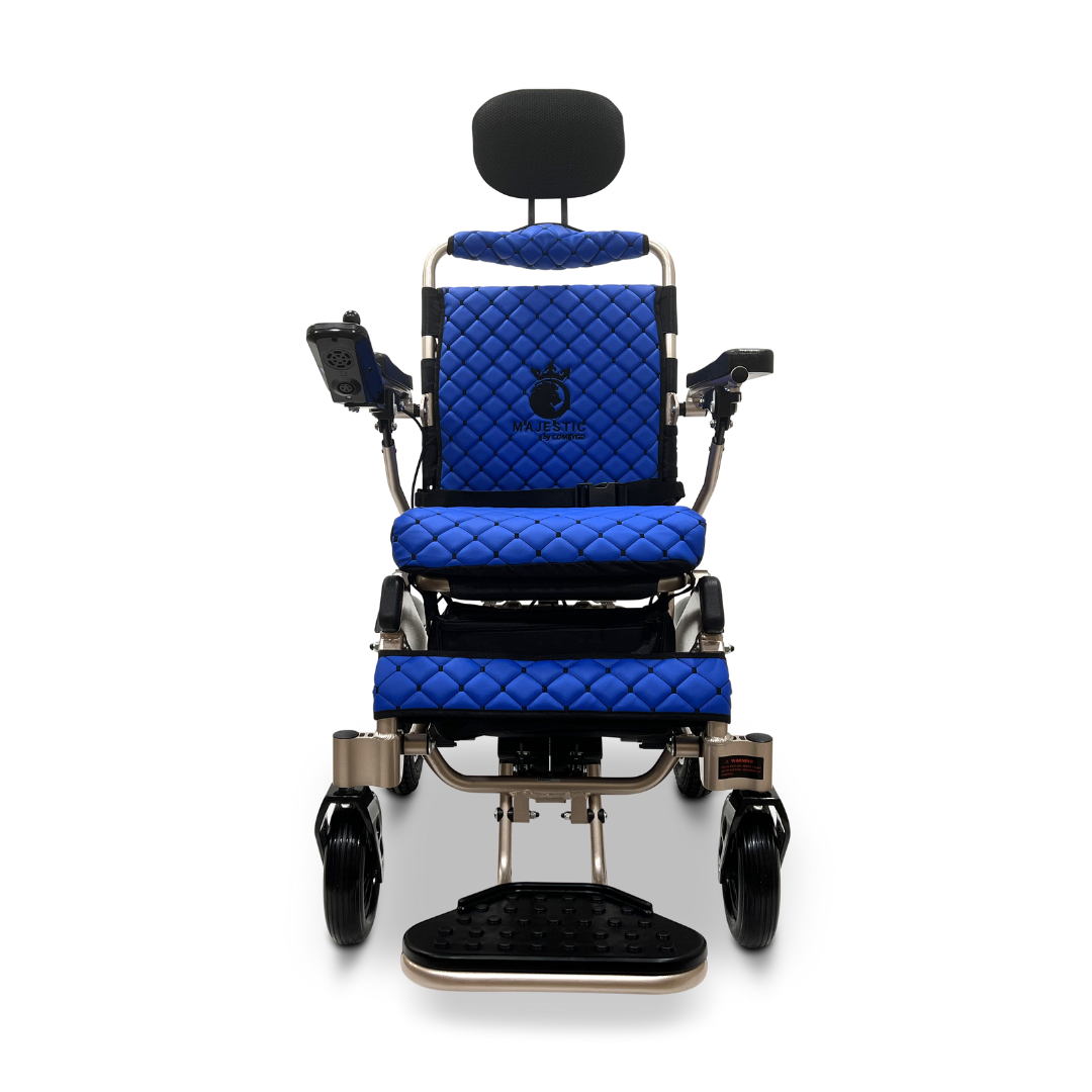 The ComfyGo MAJESTIC IQ-9000 Auto Recline Remote Controlled Electric Wheelchair showcases an elegant blue design with quilted upholstery on the seat and backrest, complete with a headrest. The digital joystick controller located on the armrest, combined with brushless silent motors, ensures smooth navigation when observed from the front view.