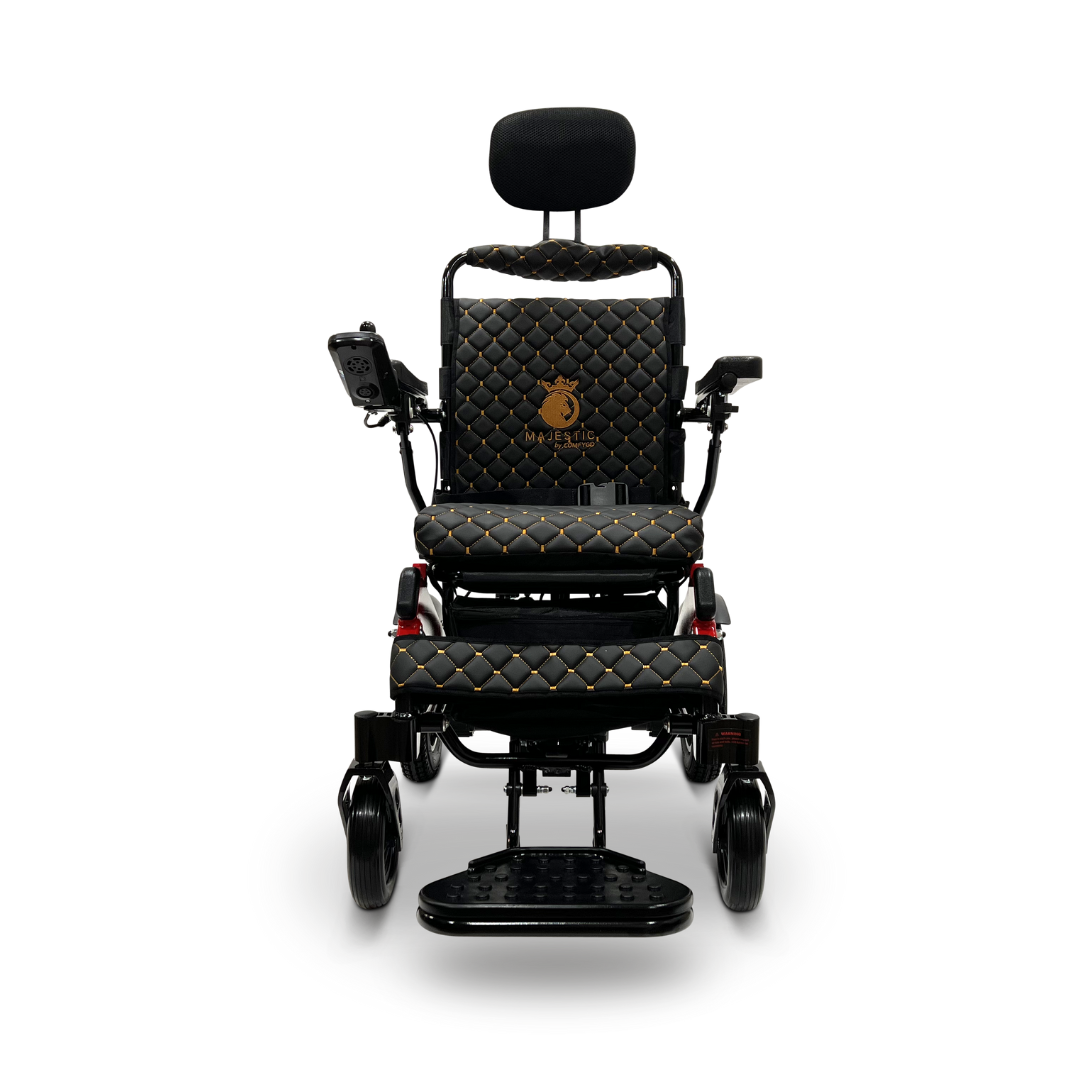 Introducing the ComfyGo MAJESTIC IQ-9000 Auto Recline Remote Controlled Electric Wheelchair, a stylish black mobility scooter with quilted cushions and gold accents. It features a digital joystick controller and brushless silent motors, complemented by an elevated footrest, comfortable headrest, and the brand logo elegantly displayed on the backrest.