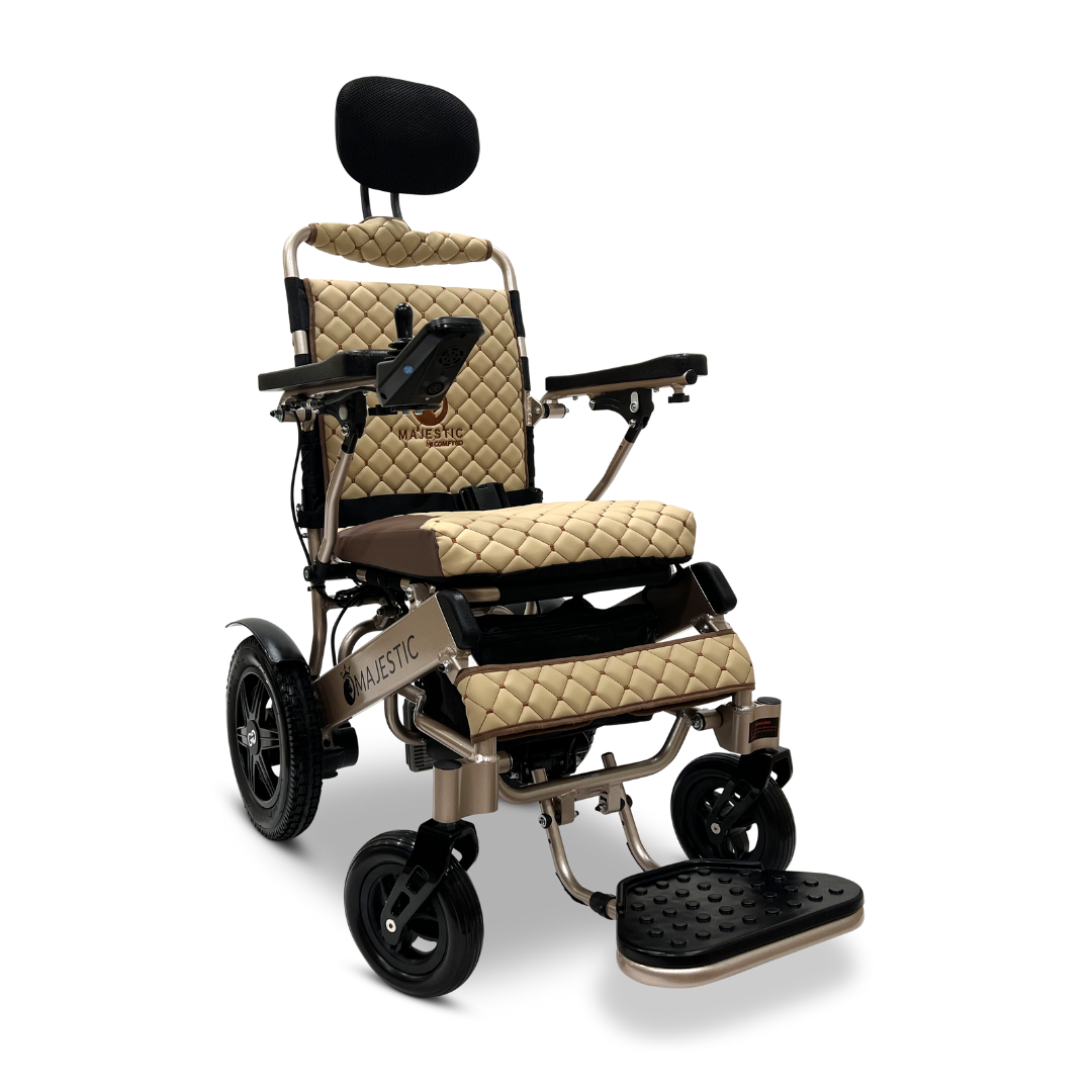 Introducing the ComfyGo MAJESTIC IQ-9000 Auto Recline Remote Controlled Electric Wheelchair, featuring a beige quilted seat and footrest. It comes equipped with a digital joystick controller, black armrests, and brushless silent motors for whisper-quiet operation. The metallic structure includes a headrest and wheels, with the control panel conveniently located on the right armrest.