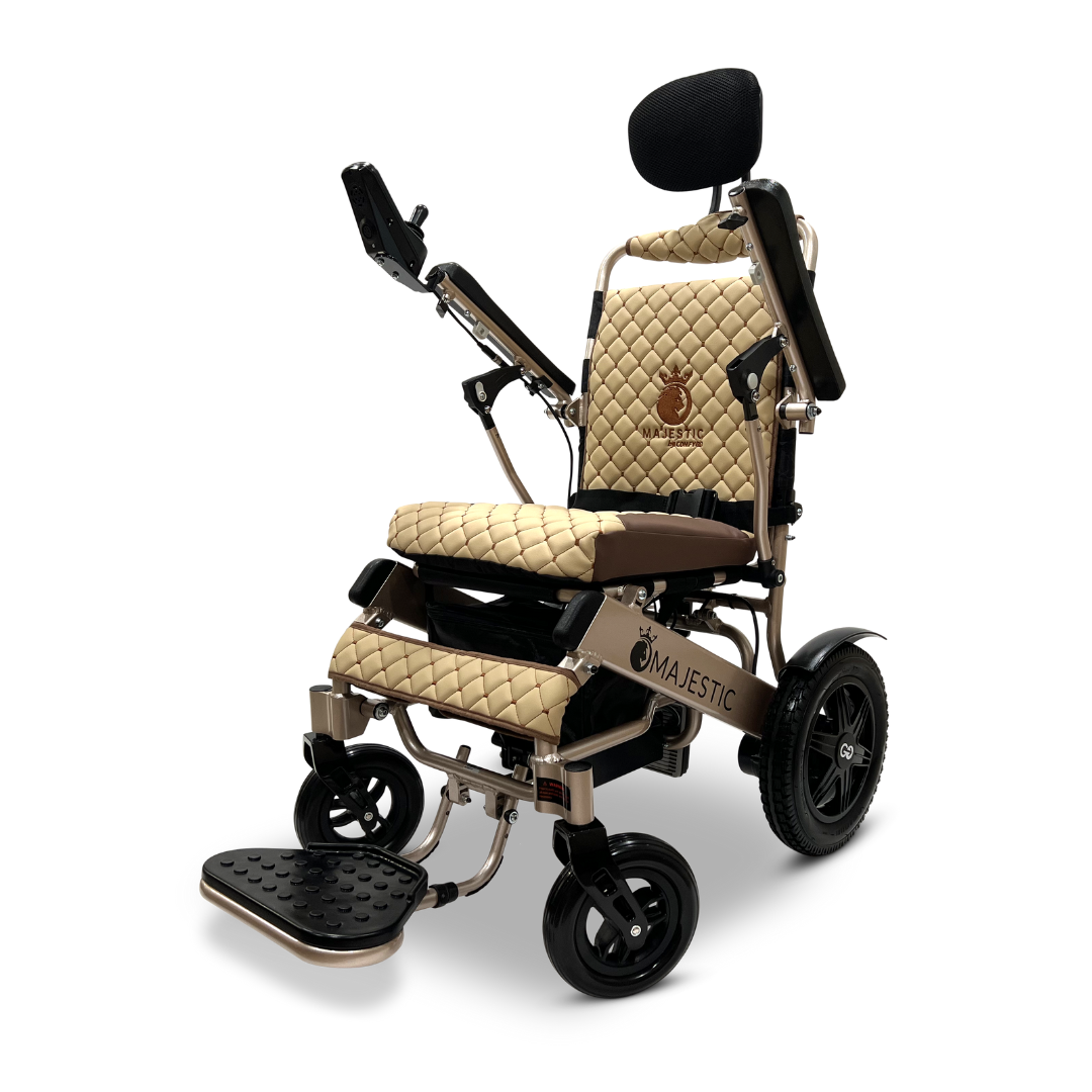 Introducing the ComfyGo MAJESTIC IQ-9000, an auto recline remote-controlled electric wheelchair. This luxurious model features a beige and black quilted seat and backrest, complete with a headrest and armrests. It is powered by brushless silent motors and comes with a digital joystick controller. Its elegance is enhanced by large rear wheels, a footrest, and the distinctive Majestic print adorning its sides.