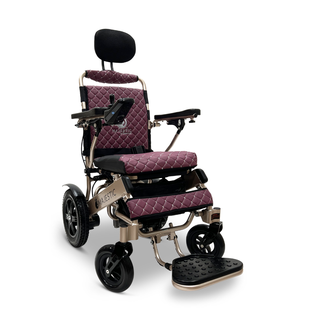 The ComfyGo MAJESTIC IQ-9000 Auto Recline Remote Controlled Electric Wheelchair, available in maroon and black, features a quilted design with padded armrests, headrest, and footrest. It includes a digital joystick controller on the right armrest and brushless silent motors that drive large rear wheels alongside smaller front wheels for seamless mobility.