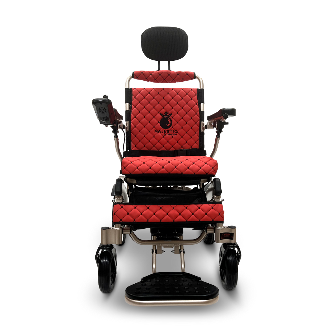 Introducing the ComfyGo MAJESTIC IQ-9000 Auto Recline Remote Controlled Electric Wheelchair: A front view of a contemporary red wheelchair with black quilted cushions, featuring a headrest, armrests, footrest, and a digital joystick controller on the right armrest. The chair is equipped with brushless silent motors, sleek black wheels, and metallic accents.