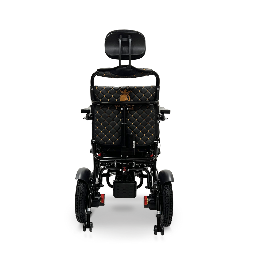 A black ComfyGo MAJESTIC IQ-9000 Auto Recline Remote Controlled Electric Wheelchair is shown from the rear, showcasing a quilted brown and gold patterned backrest and headrest. It is equipped with brushless silent motors, large rear wheels, smaller front wheels, and features a digital joystick controller on the right armrest.