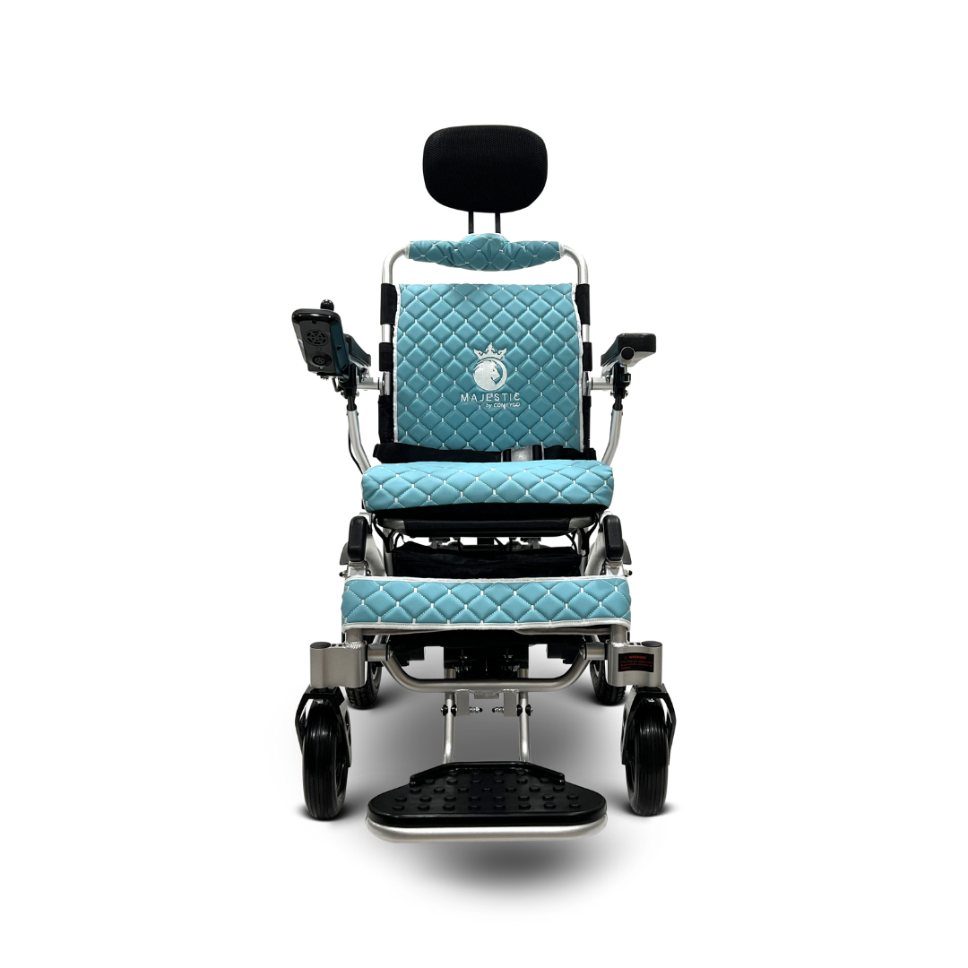 The ComfyGo MAJESTIC IQ-9000 Electric Wheelchair features quilted blue cushioning, digital joystick control for auto recline, a headrest, footrest, armrest controls, and smooth mobility with four wheels. The brand logo is elegantly displayed on the white backrest.